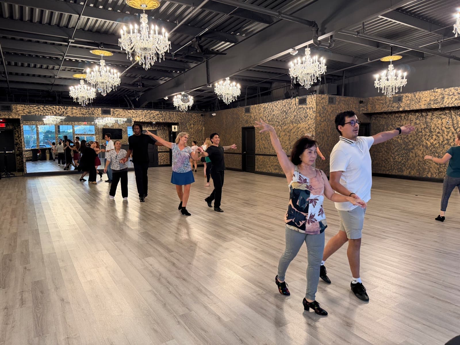 Adult beginners dancing salsa in a group class at Dance Journey Studios in Katy, TX